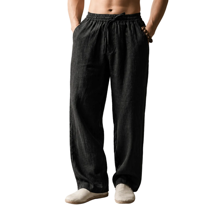Person wearing black linen pants against a white background