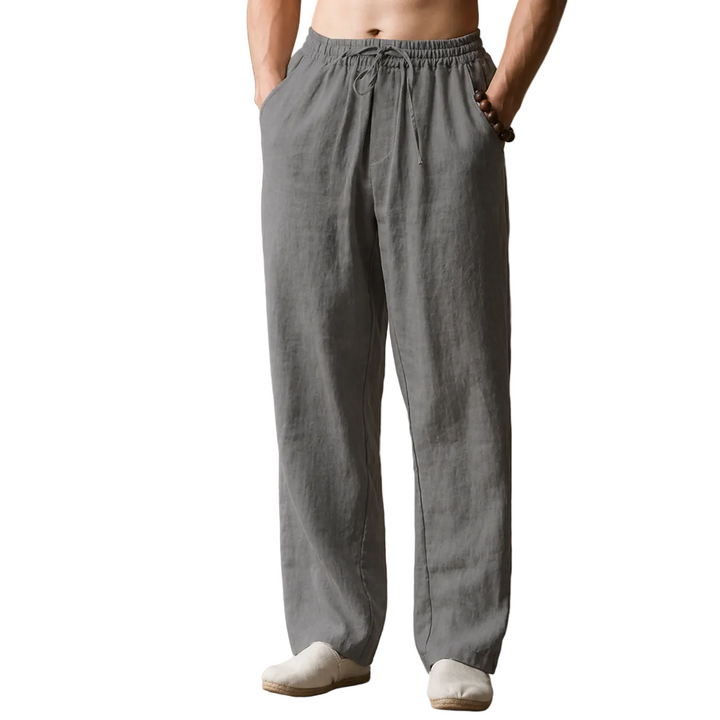 Person wearing gray linen pants against a white background