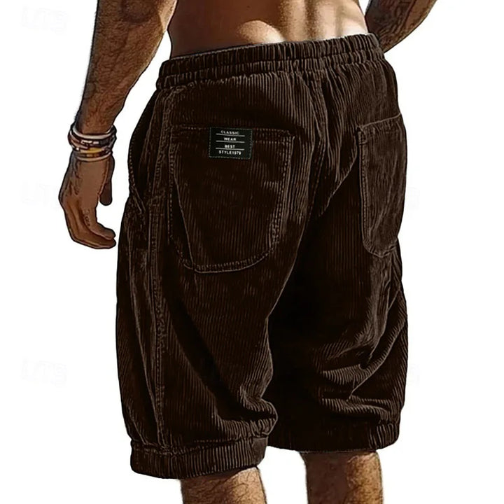 Brown corduroy shorts worn by a person on a white background