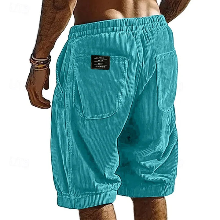 Turquoise shorts worn by a person on a white background