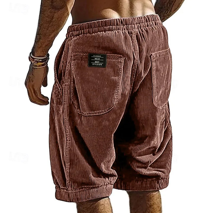 Brown corduroy shorts worn by a person on a white background