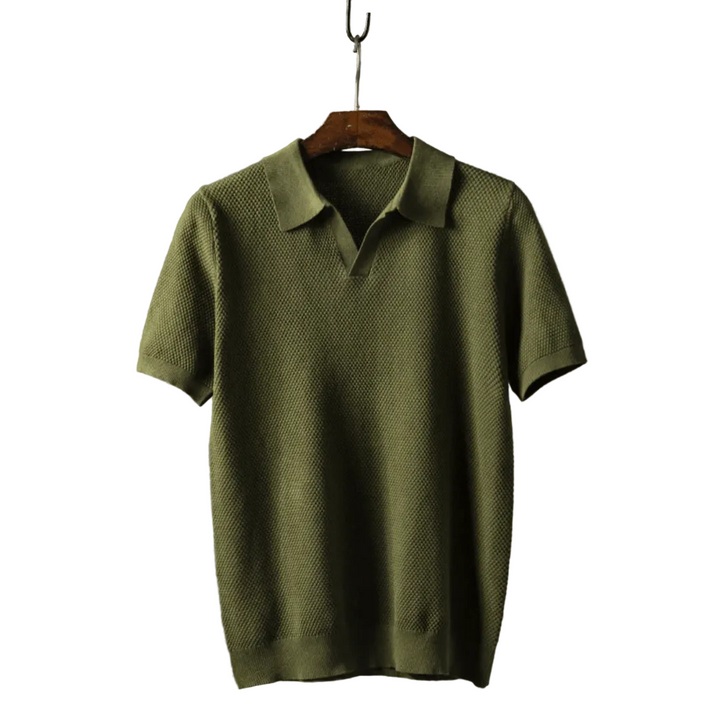 Green polo shirt on a wooden hanger against a white background