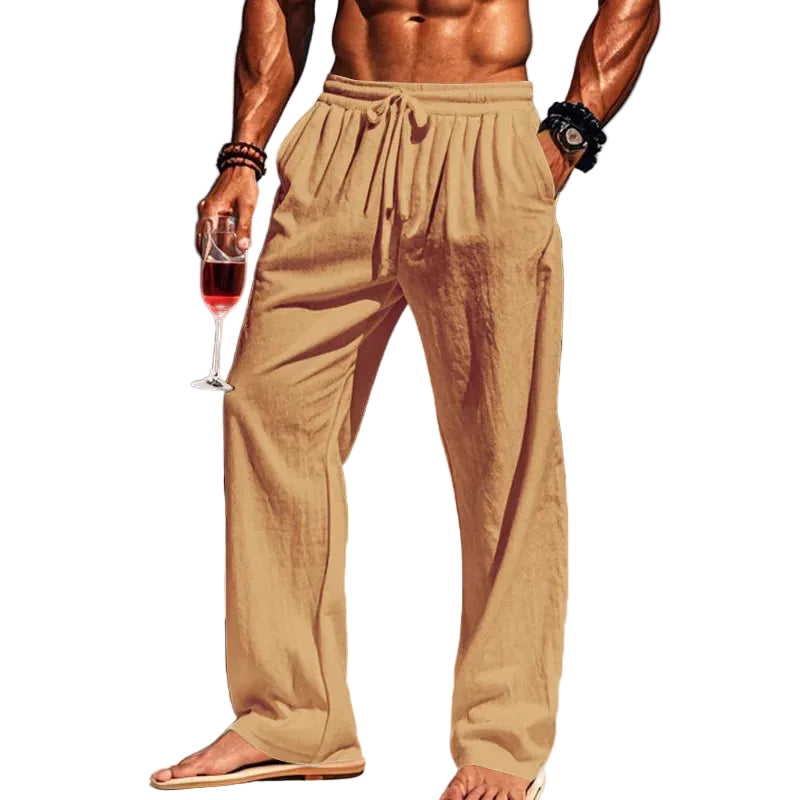 Man in beige pants holding a glass of red wine with white background