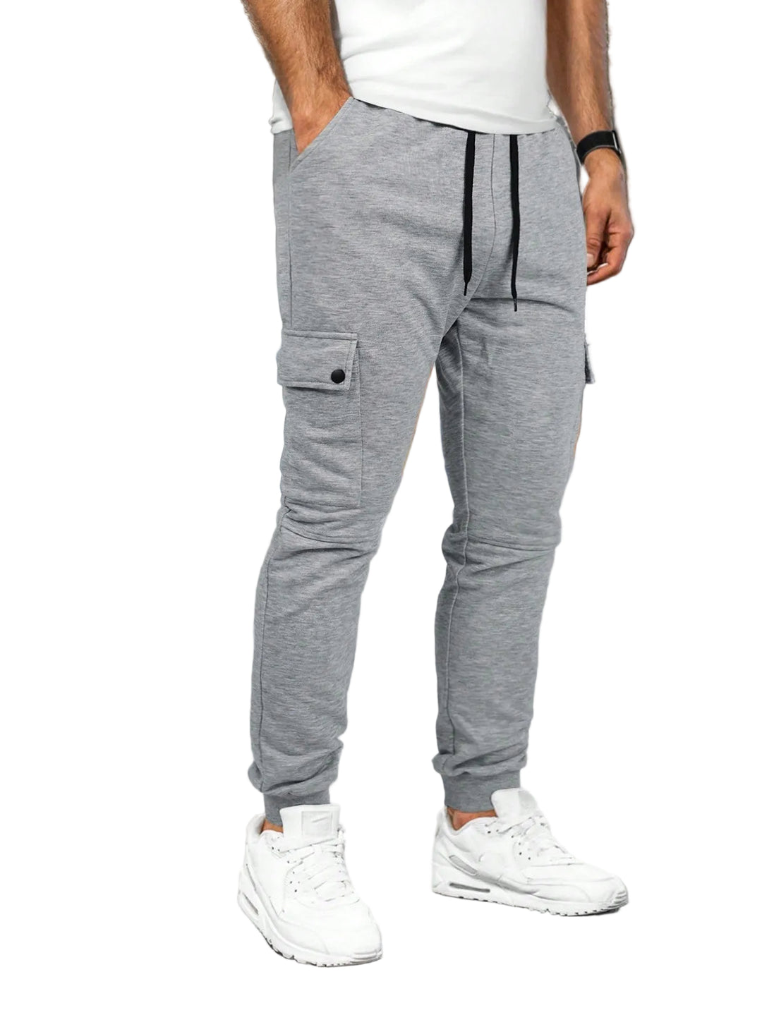 Person wearing gray jogger pants and white sneakers in a white background.