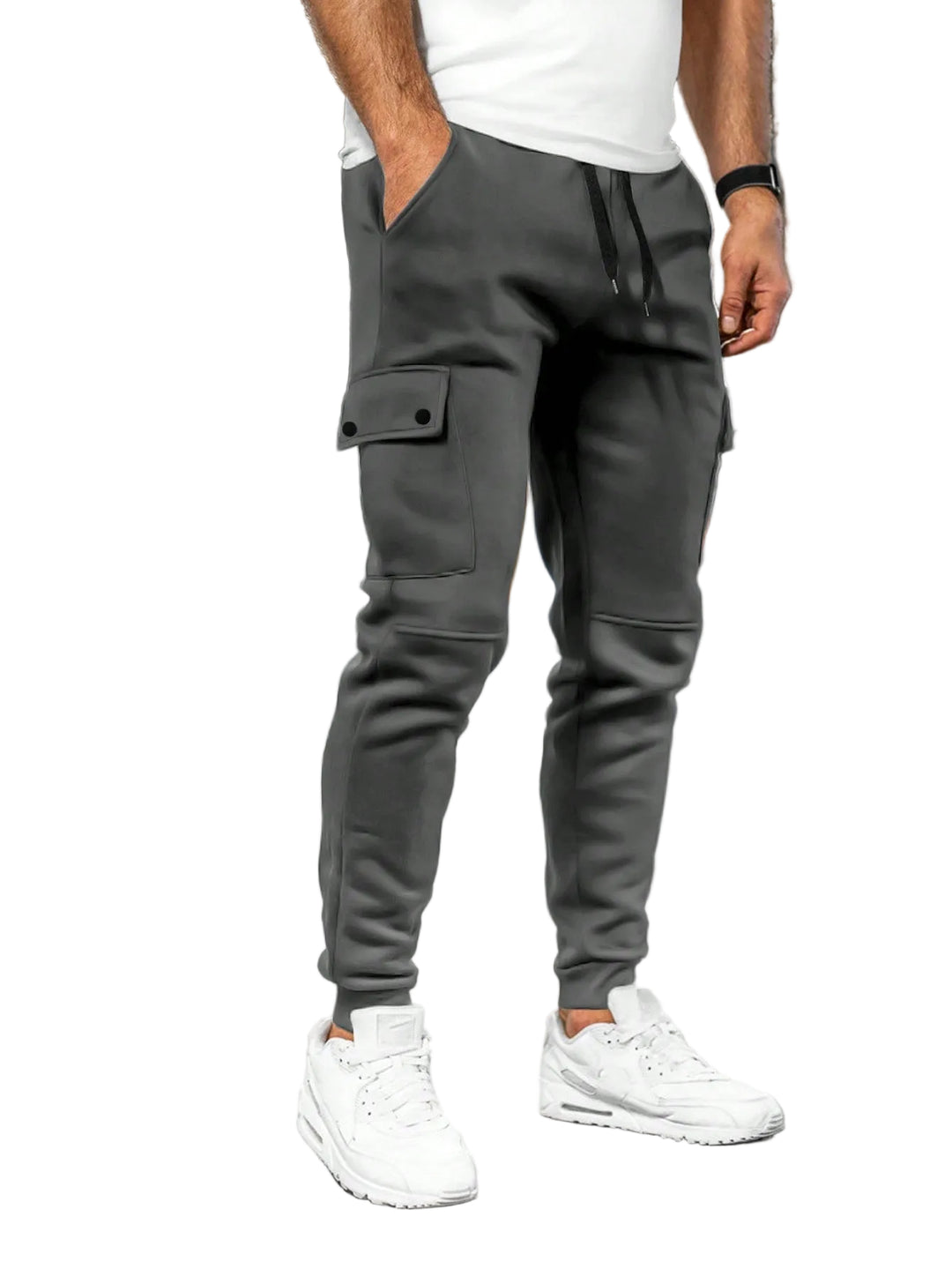 Person wearing gray jogger pants and white sneakers in a white background.