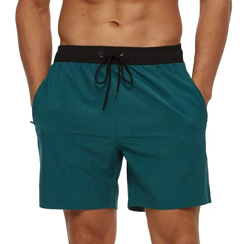 Teal swim shorts with a black waistband on a white background