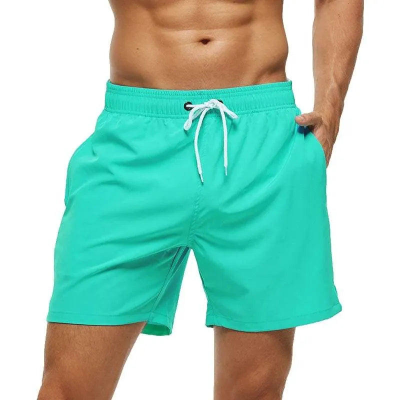 Turquoise swim shorts with a drawstring on a white background