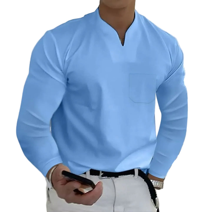 Person wearing a light blue long-sleeve shirt with a pocket, holding a phone, against a white background.