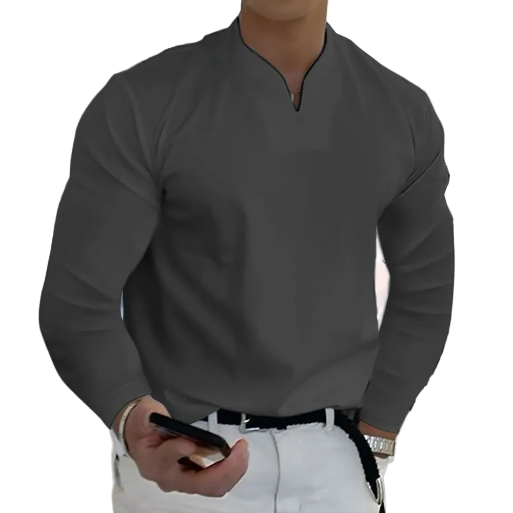 Person wearing a gray long-sleeve shirt and white pants, holding a phone.