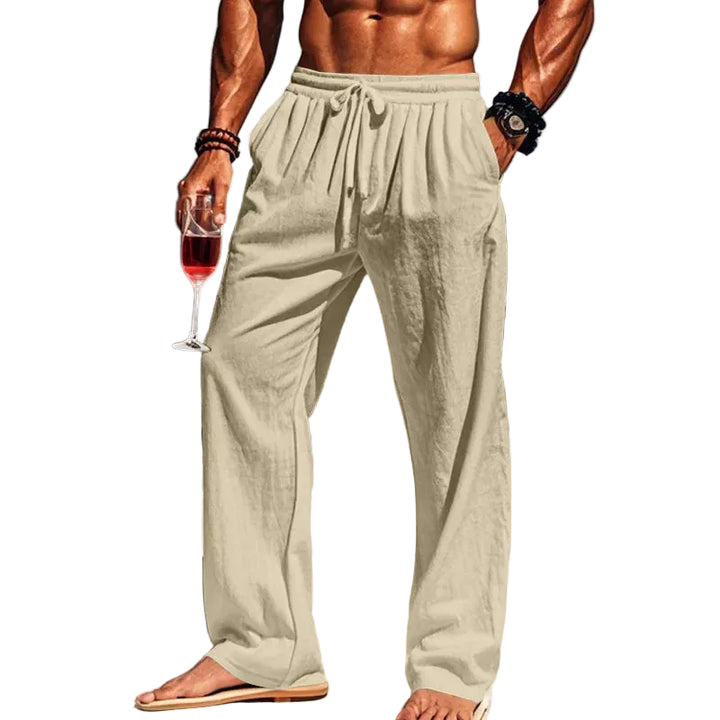 Man in light-colored pants holding a glass of red wine with white background