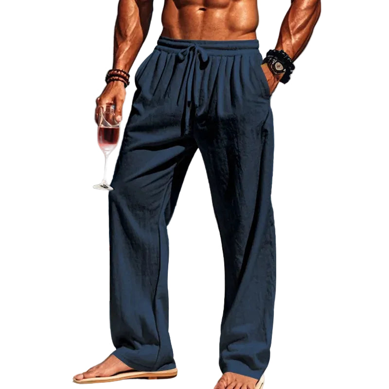 Man in navy pants holding a glass of red wine with white background