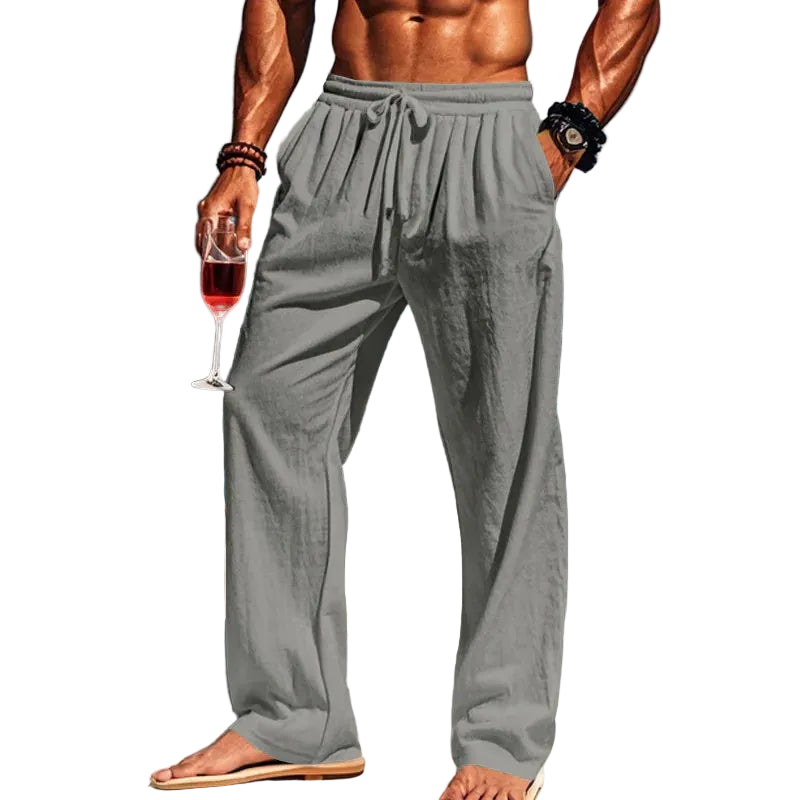 Man in gray pants holding a glass of red wine with white background