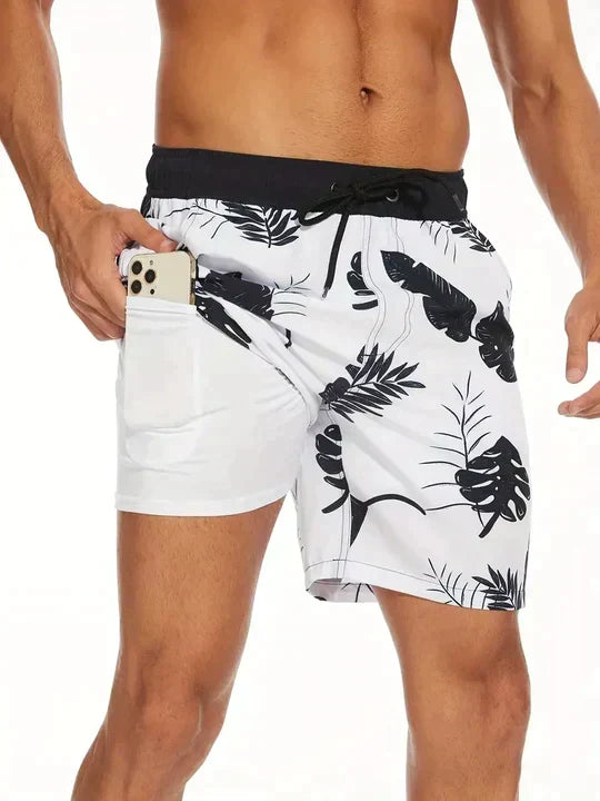 White shorts with black leaf pattern worn by a person on a white background