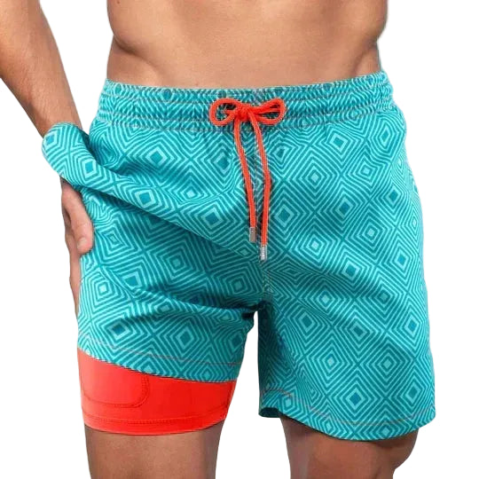 Teal swim shorts with geometric pattern and red accents on a white background