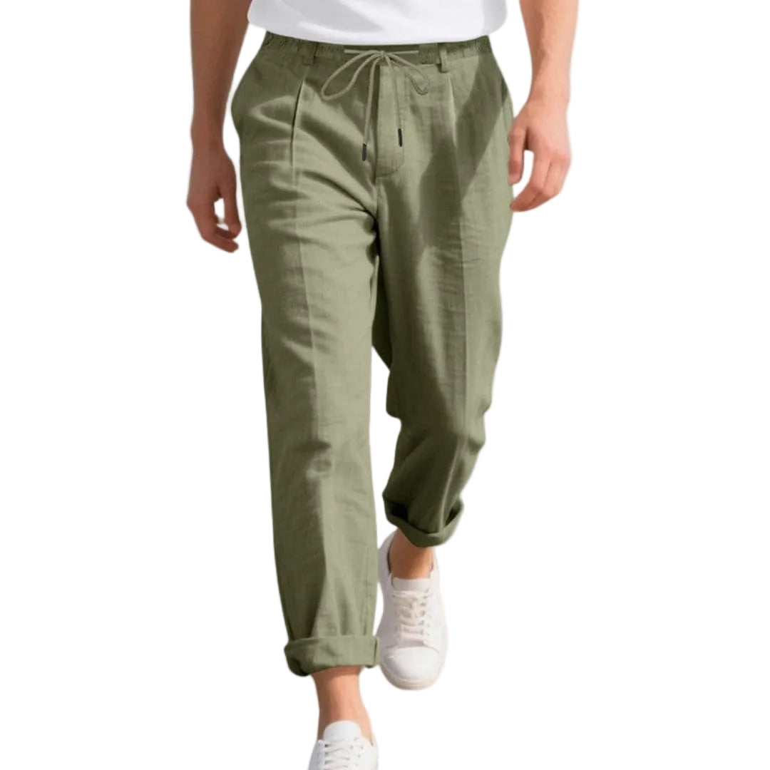 Person wearing olive green pants and white sneakers on a white background