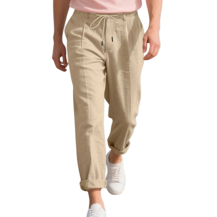 Person wearing beige pants and white sneakers on a white background