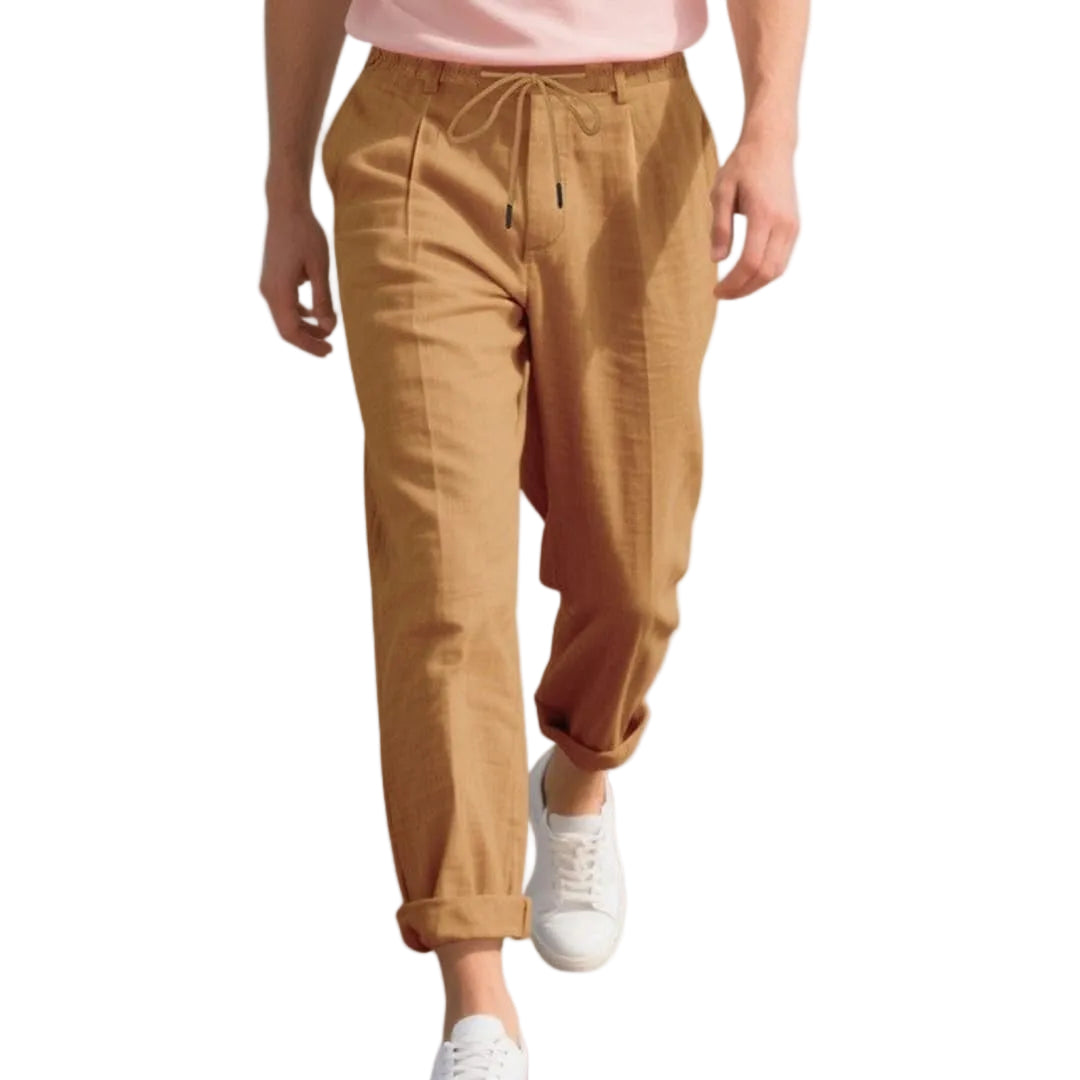 Person wearing tan pants and white sneakers on a white background