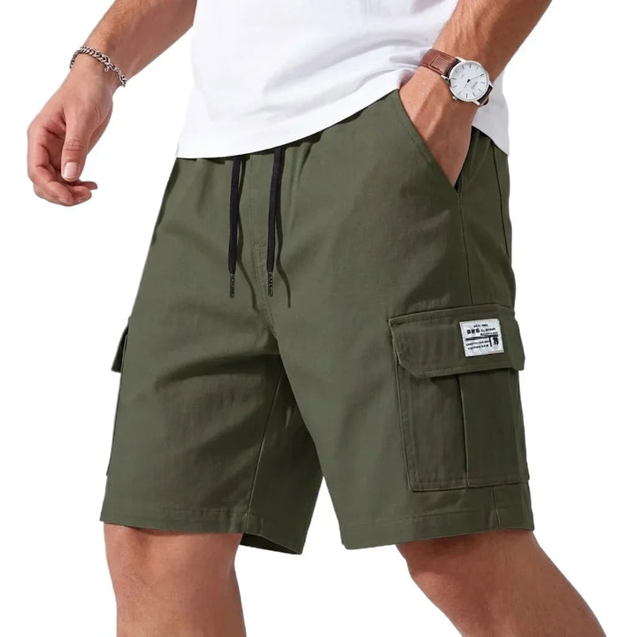 Green cargo shorts worn by a person on a white background