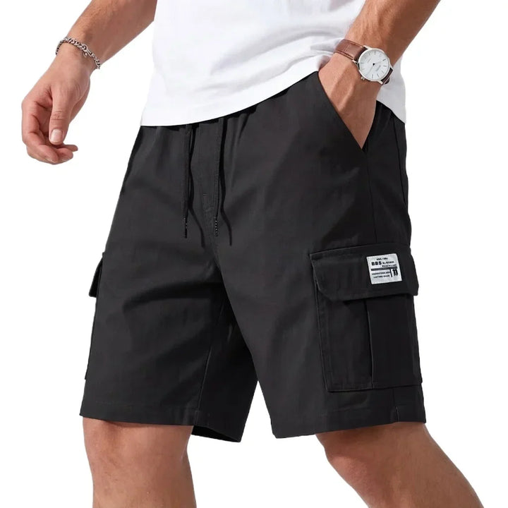 Navy blue cargo shorts worn by a person on a white background