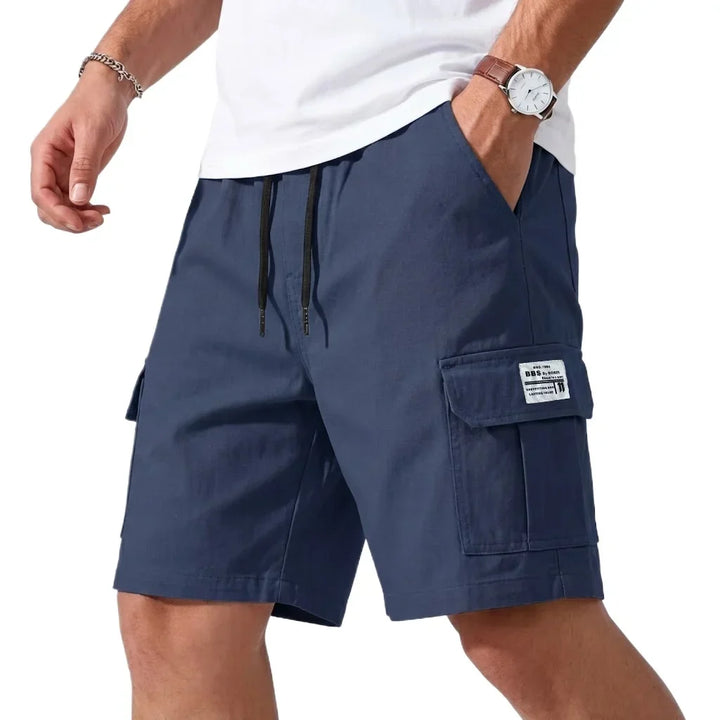 Green cargo shorts worn by a person on a white background