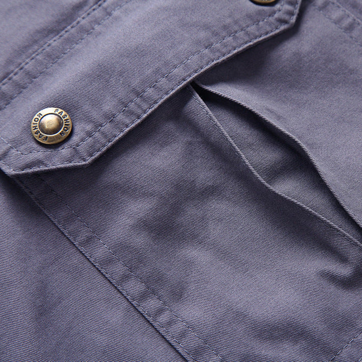 Close-up of a blue jacket with a button featuring a brand logo.