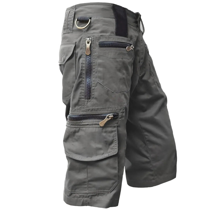 Gray cargo shorts with multiple pockets and zippers on a white background