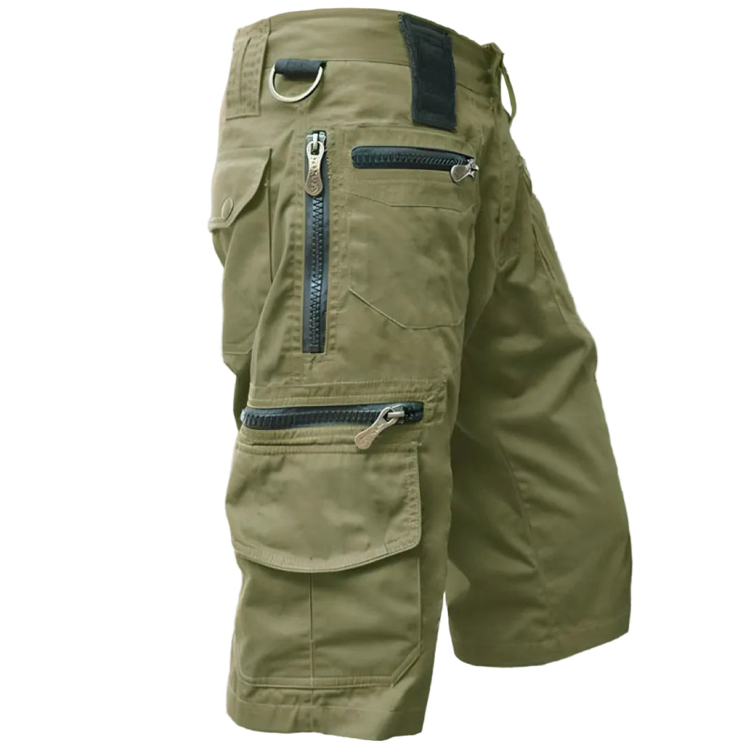 Green cargo shorts with multiple pockets and zippers on a white background
