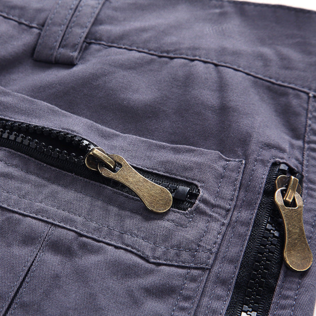 Close-up of a navy blue jacket with brass zippers and black zipper pulls.