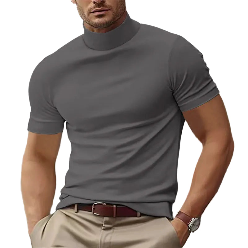 Man wearing a gray turtleneck shirt and beige pants with a white background