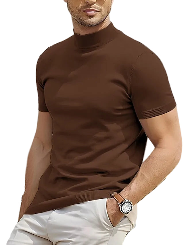 Man wearing a brown turtleneck sweater and white pants white background.