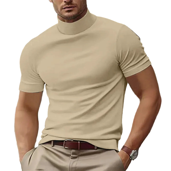 Man wearing a beige turtleneck shirt and pants with a white background