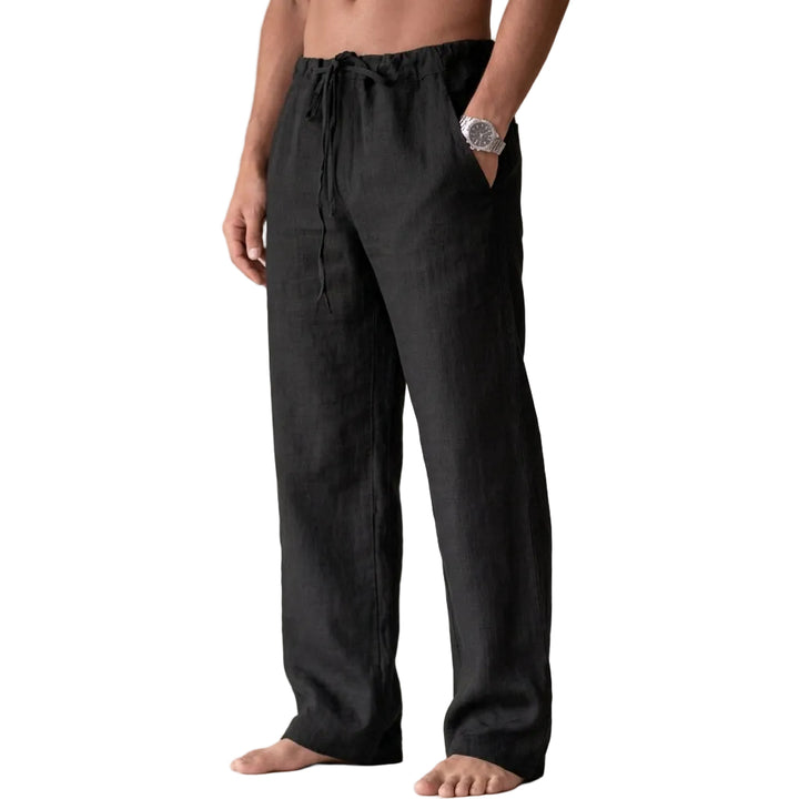 Person wearing black linen pants on a plain background